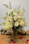 Silent Night- All White Florals with Olive Branches and wax flower in a tall glass vase